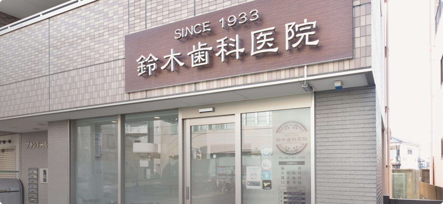 鈴木歯科医院の看板と入口が見える医院外観